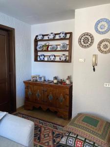 a bedroom with a dresser and plates on a wall at NIGRITELLA in Madonna di Campiglio