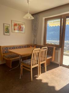 comedor con mesa, sillas y ventana en Ferienwohnung Jeller, en Lienz