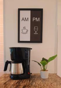 a coffee maker sitting on a counter next to a plant at Ape na Maranduba em frente à praia - Village 5 in Ubatuba