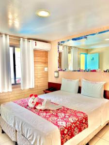 a bedroom with a bed with a stuffed animal on it at Beira Mar Porto de Galinhas Hotel in Porto De Galinhas