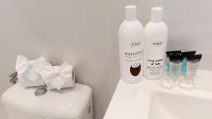 - une salle de bains avec 2 bouteilles de savon et des toilettes dans l'établissement Apartament Żurawia, à Radom