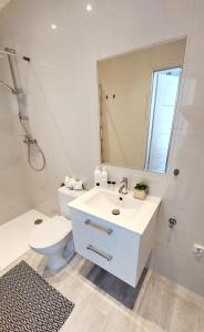 a bathroom with a sink and a toilet and a mirror at Apartament Żurawia in Radom