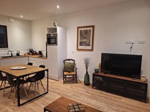 a living room with a flat screen tv and a kitchen at La perle de Houlgate in Houlgate