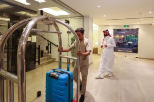 a man and a woman looking at a suitcase in a store at شقق المبات للشقق المخدومة in Riyadh