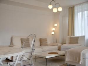 Sala de estar blanca con sillas blancas y mesa en MOONROOMS Cityapartment 2 in Bad Bevensen, en Bad Bevensen