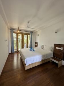 a bedroom with a large white bed and wooden floors at Thundi Sea View in Fulidhoo +68 photos