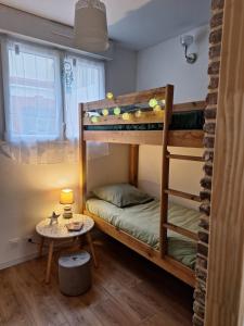 a room with two bunk beds and a table at La perle de Houlgate in Houlgate
