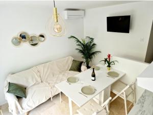a living room with a white couch and a table at Studio Au bas des crêtes en bas de villa à La Ciotat proche de la mer et de Marseille in La Ciotat