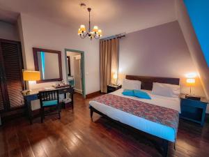 a bedroom with a bed and a table and a mirror at Via Mina Hotel in El M&icirc;na