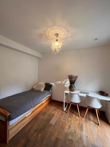 1 dormitorio con 1 cama, mesa y sillas en Chambre privée Toulouse proche métro et rocade, en Toulouse