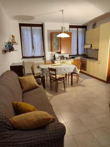 sala de estar y cocina con sofá y mesa en Domus Tilla, en Boffalora sopra Ticino
