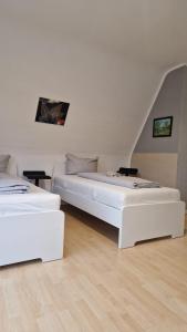 Habitación con 2 camas blancas y suelo de madera. en 2,5 Zimmerwohnung en Mönchengladbach