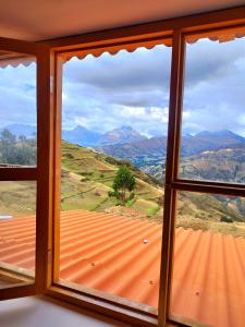 - une fenêtre avec vue sur la montagne dans l'établissement mountain view willcacocha lodge, à Huaraz