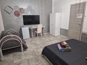 a bedroom with two beds and a desk and a television at La Habitacion del Mar in Gallipoli