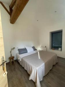 - une chambre blanche avec un grand lit et une fenêtre dans l'établissement Beaujolais - Maison pierres dorées, à Ville-sur-Jarnioux