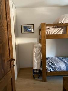 a small room with two bunk beds and a door at NIGRITELLA in Madonna di Campiglio