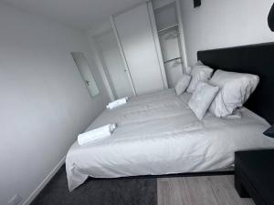 - un lit avec des draps et des oreillers blancs dans l'établissement F3 au bord de la Marne, à deux pas de Paris +Box !, à Maisons-Alfort