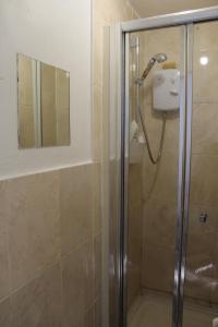 ein Bad mit einer Dusche und einer Glastür in der Unterkunft The Yellow House in London