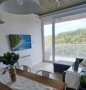 a living room with a table and a large window at Departamento frente al mar en Monte Hermoso in Monte Hermoso