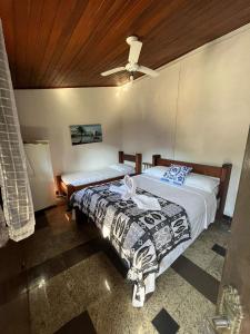 a bedroom with two beds and a ceiling at Pousada Novo Encanto Maresias in Maresias