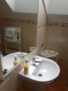 a bathroom with a white sink and a mirror at Gościniec Czapla in Dywity
