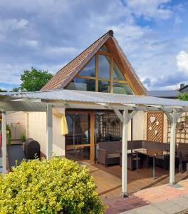 a house with a conservatory with a roof at Klein, aber fein in Sophienhof
