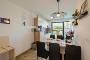 - une salle à manger et une cuisine avec une table et des chaises dans l'établissement Apartmaji BANONIA " Poletni vetrc ", à Banovci