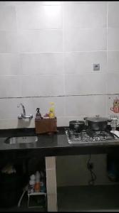 uma cozinha com um lavatório e um fogão com panelas e frigideiras em Sliceofhaven in Asilah em Asilah