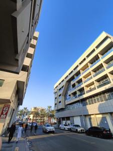 杜拜的住宿－orange hostel，大街前有车辆停放的高楼