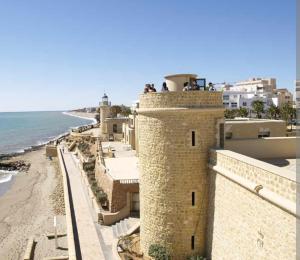people standing on top of a building next to the beach at Ático con vistas al mar in Vícar