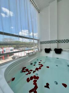 una vasca idromassaggio in una stanza con una grande finestra di Bora Bora Adults only a Melgar