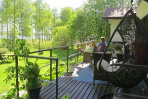 zwei Personen sitzen an einem Tisch auf einem Deck in der Unterkunft Atmospheric house on riverbank in Rovaniemi