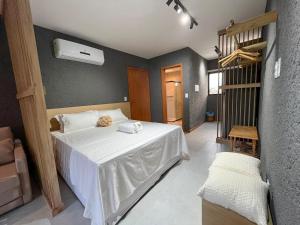 a bedroom with a white bed and a staircase at Excelente condomínio com uma belíssima área de lazer próximo à praia do Patacho in Pôrto de Pedras