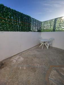 eine Terrasse mit einem Tisch und Stühlen neben einer Wand in der Unterkunft Modern Studio Just Steps from the Beach in El Jadida