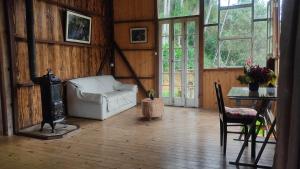 ein Wohnzimmer mit einem Sofa und einem Tisch in der Unterkunft Sítio Kikiô - À Beira Rio em Lumiar in Nova Friburgo