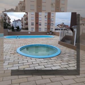 a swimming pool in the middle of a building at Apartamento com piscina, apenas 200 metros do mar in Capão da Canoa