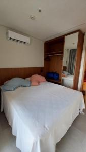 uma grande cama branca num quarto com um espelho em Salinas Premium Resort em Salinópolis