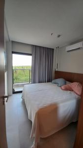 um quarto com uma cama grande e uma janela grande em Salinas Premium Resort em Salinópolis