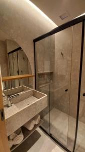 uma casa de banho com um lavatório e uma cabina de duche em vidro. em Salinas Premium Resort em Salinópolis