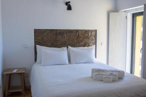 a bed with white sheets and two boxes on it at Casa do Vale in Marvão