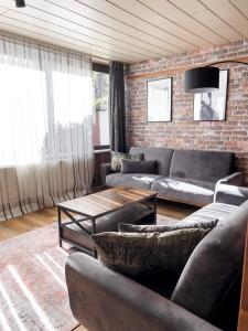 sala de estar con sofás y pared de ladrillo en FeWo Ottobeurens Schmuckstück: Gemütlich-Stylische Wohnung, en Ottobeuren