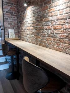a brick wall with a wooden table and two chairs at FeWo Ottobeurens Schmuckstück: Gemütlich-Stylische Wohnung in Ottobeuren