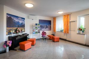 una sala de espera con taburetes naranjas y fregadero en Penzion Kovac, en Radovljica