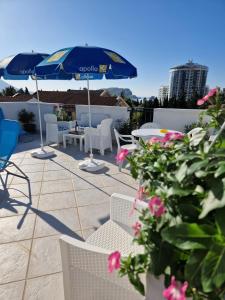 - une terrasse avec des chaises, un parasol et des fleurs dans l'établissement Apartments Tamara, à Budva