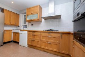 eine Küche mit Holzschränken und einem weißen Kühlschrank in der Unterkunft Stylishly Decorated Fourlex House in Istanbul