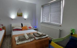 een slaapkamer met een bed met kussens erop bij Apartments Window in Bihać