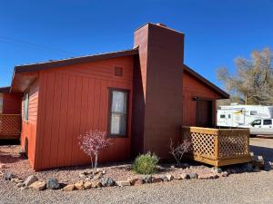 a small red house with a porch and a yard at Crazy Horse - APT 1 in Kanab