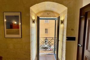 un corridoio con una porta a vetri in un edificio di Valletta Dome Apartment a La Valletta