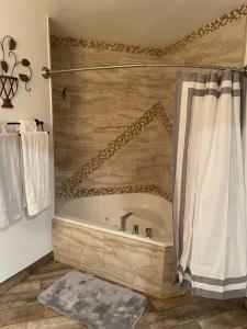 a bathroom with a bath tub with a shower curtain at Crazy Horse - APT 1 in Kanab
