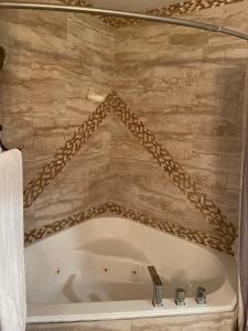 a bath tub in a bathroom with a stone wall at Crazy Horse - APT 1 in Kanab